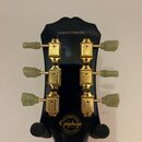 Zadní strana hlavy černé kytary s nápisem Epiphone a rokem 2014. V horní části je vyrazeno sériové číslo 14061506646. Nástroj má zlaté ladičky s bílo…