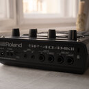 Zadní strana černého sampleru s nápisy Roland a SP-404MKII. Jsou zde vidět konektory s popisky DC IN, POWER ON OFF, MIDI OUT, MIDI IN, LINE IN R, LIN…