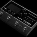 Černý multi-efektový procesor s displejem a několika ovládacími knoflíky. Na spodním panelu je bílý nápis VALETON GP-200LT MULTI-EFFECTS PROCESSOR. Z…