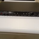 Zadní strana černého rackového zařízení značky SPL. Jsou zde viditelné nápisy VOLTAGE SELECTOR, CAUTION, MASTER, COMP LINK, AD INPUT, ANALOG OUTPUTS…