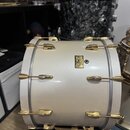 Bílé basové buben s pozlaceným hardwarem. Uprostřed korpusu je umístěn zlatý štítek s nápisem „Pearl Masters Series“. Povrch nástroje je hladký a v d…