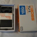 Bílá efektová pedál s černým spínacím tlačítkem a displejem. Na zařízení jsou nápisy BOSS, Chromatic Tuner TU-3, OUTPUT, INPUT a BYPASS. Vedle pedálu…