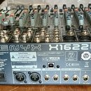 Zadní strana mixážního pultu značky behringer s nápisem XENYX X1622USB. Zařízení má kovové šasi s černým povrchem a řadou ovládacích prvků v horní čá…