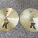 Dva mosazné činely typu hi-hat s viditelným kování povrchu. Oba mají černý nápis „LIGHT HIHAT“ a pod ním rozměr „15"/38 cm“. V dolní části je u obou…