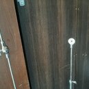 Fotografie zobrazuje dva kovové, stříbrné stojany nebo držáky s teleskopickým mechanismem. Jsou umístěny před tmavou dřevěnou stěnou. Na předmětech n…