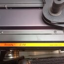 Detailní pohled na tmavě fialové kovové zařízení. Na spodní hraně je žlutý štítek s nápisy „Serenity™ Z10“ a webovou adresou „www.rvetec.com“. Povrch…