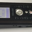 Černý přenosný digitální záznamník s texturovaným povrchem. Na zařízení jsou nápisy KORG, SOUND on SOUND UNLIMITED TRACK RECORDER a ovládací prvky ja…