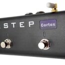 Černý MIDI kontrolér s pěti stříbrnými spínači. Na přední straně je bílý nápis AIRSTEP a vedle něj fialový obdélníkový štítek s nápisem Cortex. Zaříz…