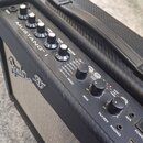 Černý kytarový kombozesilovač s nápisem MUSTANG I. Na ovládacím panelu jsou knofíky pro Gain, Volume, Treble, Bass a Master, dále sekce PRESET s tlač…