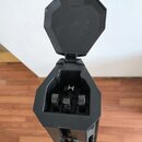 Fotografie zachycuje otevřený černý tvrdý kufýr na hudební nástroj. V interiéru jsou vidět plastové úchyty a v zadní části bílé písmeno H. Povrch kuf…