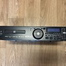 Černý rackový MP3 přehrávač s nápisy Numark na levém a pravém okraji. Na předním panelu je uvedený model MP 103 USB a nápis PROFESSIONAL MP3 MEDIA PL…
