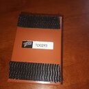Oranžový obdélníkový předmět s dvěma černými suchými pásky. Uprostřed je bílá nálepka s logem TDRIVE a označením TD0293. Povrch předmětu vykazuje mír…