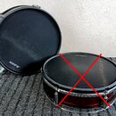 Dvě elektronické bubnové pady značky ALESIS. Jeden pad je zobrazen zepředu a druhý z profilu, oba mají černou hrací plochu a chromované obruče. Na hr…
