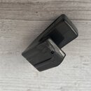 Černý plastový předmět s obdélníkovým tvarem a zaoblenými hranami. Povrch je hladký a glossy, v horní části jsou vidět drobné škrábance. Na předmětu…