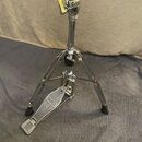 Chromovaný kovový stojan s pedálem, pravděpodobně hi-hat. Na pedálu je viditelné logo MAPEX. Povrch kovových částí je lesklý, na spodních koncích nož…