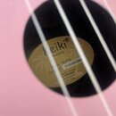 Detail znázorňuje otvor rezonanční desky růžového nástroje, uvnitř kterého je nalepený štít. Na štítku je nápis Keiki ukuleles, Model: K2-FYD a Seria…