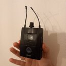 Černý bezdrátový vysílač s dvěma anténami. Na spodní části je bílé logo AKG a nápis SPR 4500. Povrch plastového krytu vykazuje viditelné škrábance a…