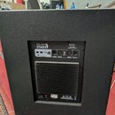 Zadní strana černého aktivního subwooferu s texturovaným povrchem. Na ovládacím panelu jsou nápisy ITALIAN STAGE, S118A a HIGH OUTPUT POWERED SUBWOOF…