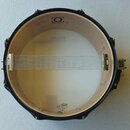 Fotografie znázorňuje snare drum z pohledu zespodu. Na vnitřní straně obruče je nápis DRUMCRAFT s logem. Na spodním koženě je vidět logo REMO a nápis…