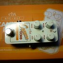 Bílá efekt pedál s nápisy Canyon ECHO, NYC DSP a logem ehx. Pedál má čtyři bílé ovládací knoflíky s popisky FILTER, BLEND, FDBK a DELAY, dále tlačítk…