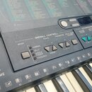 Detailní pohled na ovládací panel a klávesy elektronického klavíru. Na panelu jsou nápisy OVERALL CONTROLL, TEMPO, TRANSPOSE a SPLIT POINT CHANGE. V…