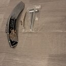 Na fotografii je chromovaný kovový kryt hlavy kytary a součástí montáže v plastovém sáčku. Na krytu je nápis „Gold Tone“ a dekorativní ornamenty. Pov…