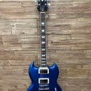 Modrá elektrická kytara s dvojsekerou tvaru těla a dvěma humbuckery. Na hlavě hmatníku je bílý nápis Epiphone. Hmatník má bílé blokové vložky a na hr…