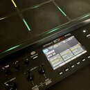 Černý sampling pad značky Roland s nápisem SPD-SX PRO. Zařízení má mřížku gumových padů s podsvícením v různých barvách. Displej zobrazuje název „001…