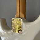 Detail zadní strany bílé elektrické kytary v místě spoje krku s tělem. Na zlatém kovovém krytu hрифu je vyražen nápis 1957 2007 a sériové číslo V1712…