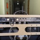 Zadní strana kytarového komba v béžovém potahu. Na černém ovládacím panelu jsou nápisy „SUPER SONIC“, logo „Fender“ a sériové číslo „CR-305485“. Jsou…
