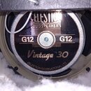 Fotografie zachycuje zadní stranu reproduktoru v černém koženkovém pouzdře. Na magnetu je vidět nápis CELESTION LOUDSPEAKERS, dvakrát označení G12 a…