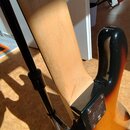 Detail zadní části krku a spoje s tělem elektrické kytary. Tělo má lakování v přechodu od černé k žluté barvě, krk je z nebarveného dřeva. Na kovém k…
