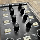 Detailní pohled na ovládací panel kontroléru s nápisy TRAKOR a N1. Panel obsahuje několik černých otočných knoflíků, bílá tlačítka s označením ON a č…