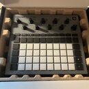 Šedý sampler Novation Circuit Rhythm v originální krabici s polystyrenovou výplní. Na horní části jsou ovládací knofíky a nápisy Master Volume, 1 Tut…