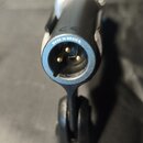 Detailní pohled na černý konektor s třemi zlatými piny. Nad konektorem je bílým písmem nápis MADE IN MEXICO a nad ním značka CE. Povrch plastu je mat…