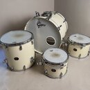 Sada bicích bubnů v krémové barvě s chromovaným hardwarem. Na přední kožeh basového bubnu je černé logo GRETSCH. Ostatní bubny mají na korpusu malé č…