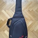 Černý polotvrdý pouzdro na kytaru z textilního materiálu. V dolní části je červený nápis Fender. Pouzdro má připevněné úchytné madlo a zipy po obvodu…