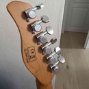 Zadní strana dřevěné hlavy kytary s šesti chromovanými ladicími mechanismy. Na dřevě je černý štítek s nápisy CE, MADE IN INDONESIA a SERIAL NUMBER 2…