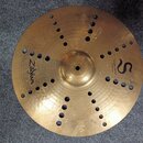 Zlatý kovový činel s otvory v povrchu. Na povrchu jsou nápisy Zildjian, TRASH CRASH a 16"/40 cm spolu s logem ve tvaru písmene S. V dolní části je dr…