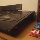 Černý digitální vícetrackový záznamový systém s ovládacím panelem plným posuvníků a tlačítek. Na zařízení je vidět nápis TASCAM a model MOSTUDIO 828.…