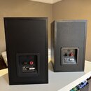 Dva černé regálové reproduktory s matným povrchem. Na zadní straně obou kusů je vidět logo KEF AUDIO MFG LTD a štítek s nápisy KEF Q10 SP3168, IMP 8…