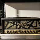 Černý kytarový kombozesilovač s texturovaným povrchem a zlatým předním panelem. Na černé mřížce je umístěno oválné logo EVH a nápis 5150 III CGW EL34…
