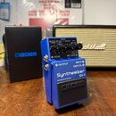 Modrý efekt pedál s nápisem Synthesizer SY-1 a logem BOSS na spodním černém spínači. Na horním ovládacím panelu jsou čtyři černé otočné knoflíky a př…