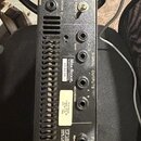 Zadní strana rackového studia předzesilovače černé barvy. Na horní části je nápis MESA/BOOGIE STUDIO PREAMP a text MADE IN USA, CALIFORNIA. Jsou zde…