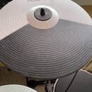 Fotografie zachycuje gumový pad elektronického činely v dvoubarevném provedení, horní polovina je bílá a spodní šedá. Na horní části je vyražen nápis…