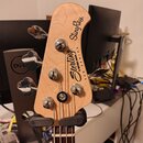 Fotografie zachycuje hlavu basové kytary z přírodního světlého dřeva. Na hlavě jsou vidět nápisy „StingRay“ a „Sterling by MUSIC MAN SUB SERIES“. Nás…