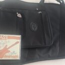 Černý polstrovaný obal na nástroj s logem Fender v oválném rámečku. Před obalem leží CD v plastovém boxu s nápisy BASS, friends a Juroj Griglák. Na o…