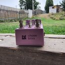 Fialový efekt pedál s kovovým šasi. Na přední straně je bílý nápis „chase bliss“ a doprovodné logo. Horní panel obsahuje dva kovové ovratidla, dva př…