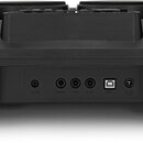 Záběr na zadní panel černého elektronického hudebního zařízení z plastu. Jsou zde vidět konektory s popisky AUX IN, PHONES, KICK, HI-HAT a USB port.…