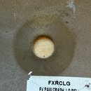 Detail středu kovového činele s otvorem. Na bílé nálepce je uveden kód FXRCLG a text FX RAW CRASH, LG BELL spolu s čárovým kódem. Povrch kovu vykazuj…
